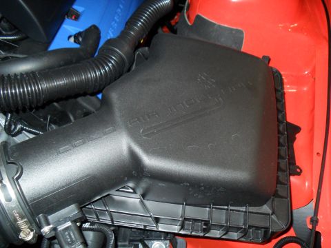 2012 Ford Mustang - Engine air intake housing with visible text 'COYOTE AIR INTAKE'.