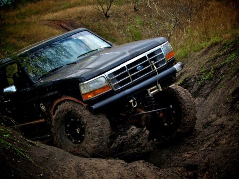 1995 Ford Bronco - This modified Ford Bronco is shown off-roading on a steep, muddy trail.