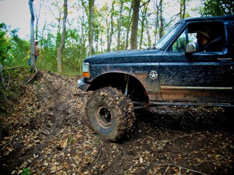 1995 Ford Bronco - Muddy 1995 Ford Bronco navigating a challenging off-road course.