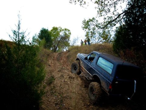 1995 Ford Bronco - This 1995 Ford Bronco is navigating a steep, muddy incline during an off-road excursion.