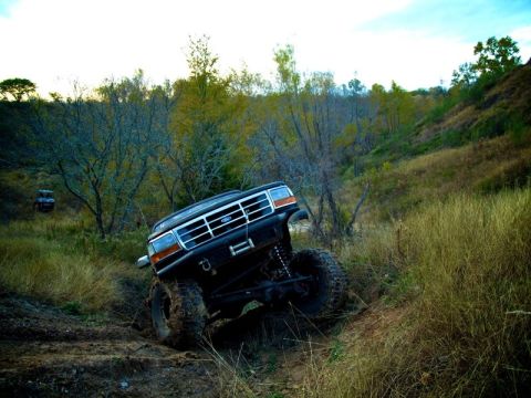 1995 Ford Bronco - Off-road adventure with a 1995 Ford Bronco navigating a challenging dirt trail.