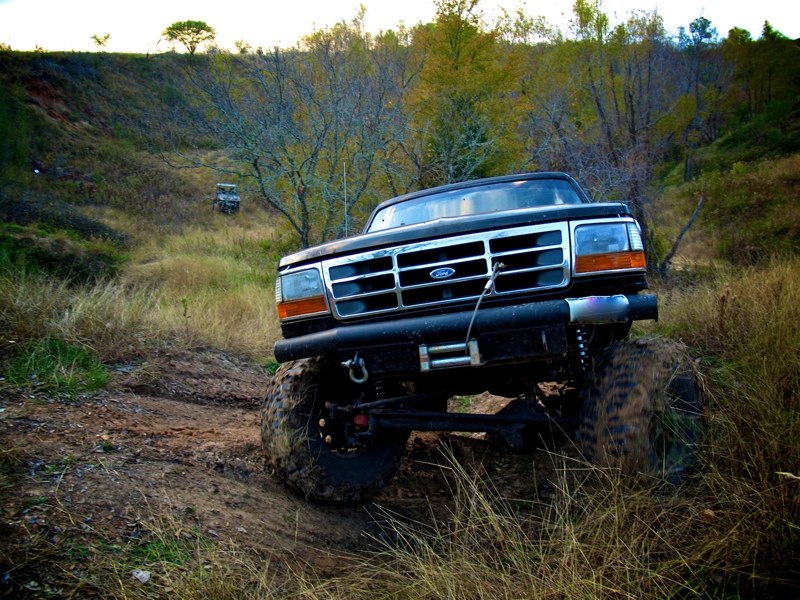 Black Ford Bronco on a dirt trail, another SUV in the background going uphill