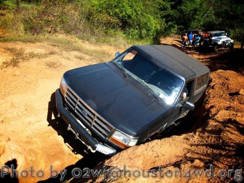 1995 Ford Bronco - 1995 Ford Bronco tackling a challenging off-road course with friends and other vehicles present.