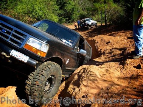 1995 Ford Bronco - This 1995 Ford Bronco is tackling a challenging off-road obstacle on a sunny day.