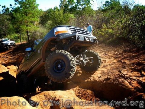 1995 Ford Bronco - This modified 1995 Ford Bronco tackles a steep dirt trail with one wheel lifted.