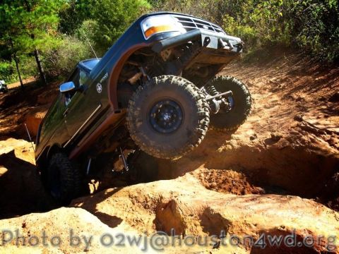 1995 Ford Bronco - This Ford Bronco is tackling a challenging off-road obstacle, its suspension and tire grip.