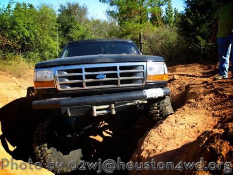1995 Ford Bronco - Ford Bronco navigating a difficult off-road obstacle, winch engaged.
