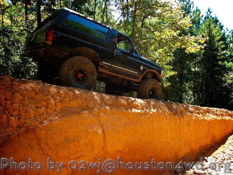 Black Ford Bronco with lifted suspension driving on a dirt ridge