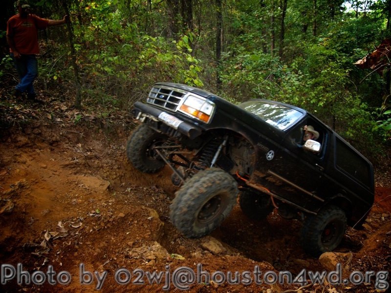 Black 1995 Ford Bronco climbing a steep dirt hill off-road