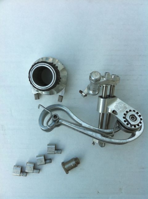 2010 Hyundai Genesis - Several parts of a bicycle rear derailleur are laid out on a light-colored surface.