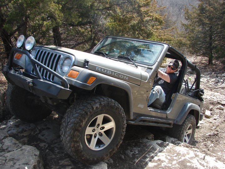 Tan Jeep Wrangler Rubicon off-roading on rocks
