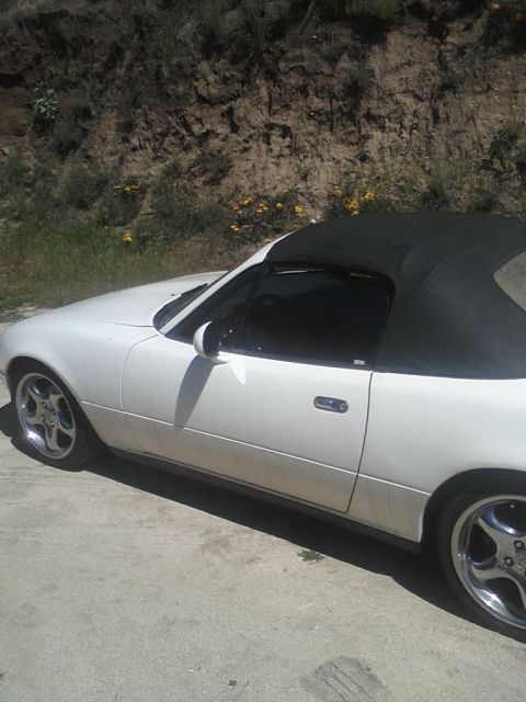 1968 Ford Mustang - Driver-side profile of a white pop-up-headlight roadster with a black soft top up, body-color mirrors and polished multi-spoke alloy wheels…