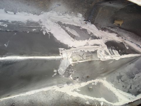 1992 Ford C-350 (Centurion Conversions) - Filler applied to metal underbody panels during repair work.