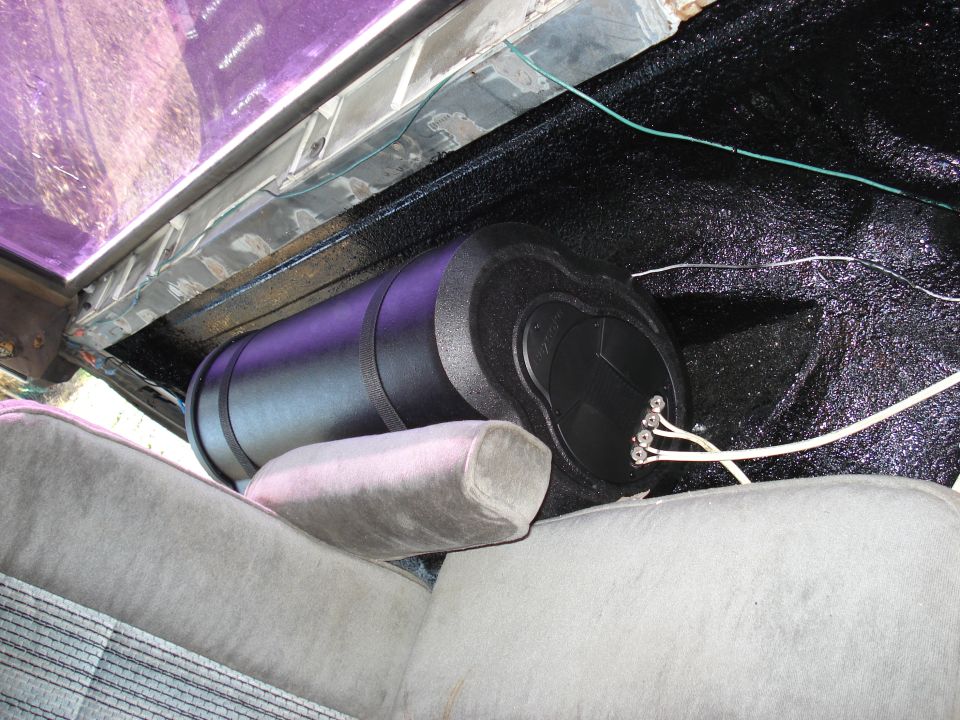 subwoofer and amplifier mounted behind vehicle seat