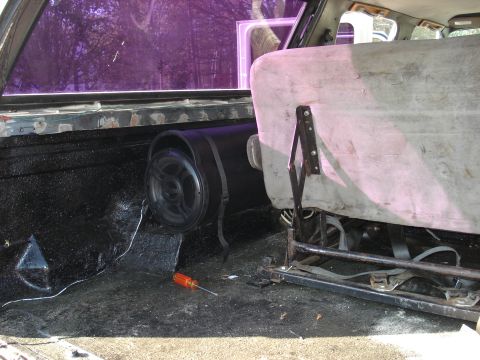 1992 Ford C-350 (Centurion Conversions) - Interior view shows a subwoofer installed behind the seat, with a screwdriver nearby.