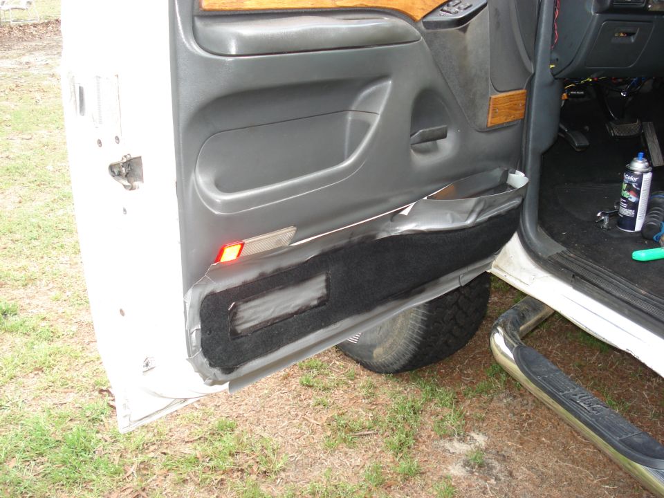 Truck door panel with lower carpet taped back for spray paint, Dupli-Color can on sill