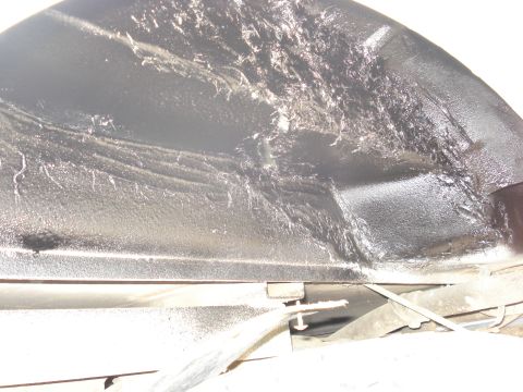 1992 Ford C-350 (Centurion Conversions) - Underside close-up of a truck's inner wheel well and rocker panel freshly coated in thick, glossy black undercoating with visible runs and…