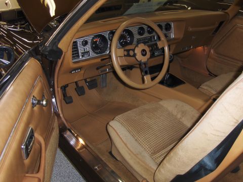 1979 Chevrolet Camaro - The interior of a classic car features tan upholstery and a dashboard with gauges.