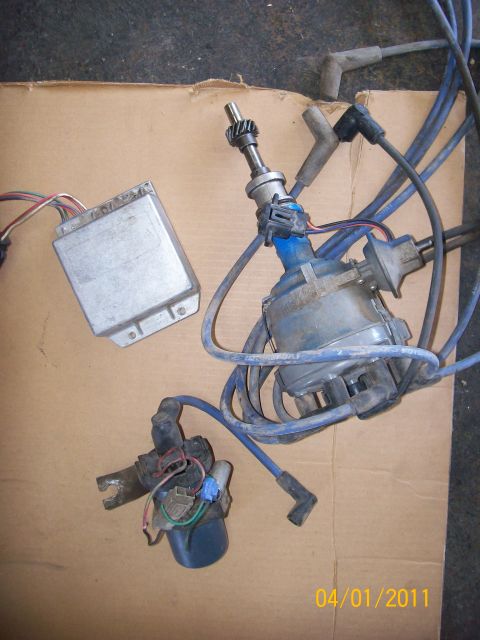 1970 Ford Bronco - Automotive ignition system parts are laid out on a piece of cardboard.