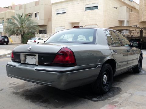 2001 Mercury Grand Marquis - Rear view of a gray Mercury Grand Marquis with black steel wheels parked on a paved surface.