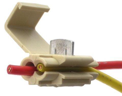 1990 Ford Bronco - A close-up view of a tan plastic wire connector with two wires attached.