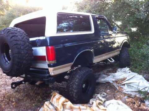 1990 Ford Bronco - This Ford Bronco, likely from the late 1980s, is modified with off-road tires and a spare tire carrier.