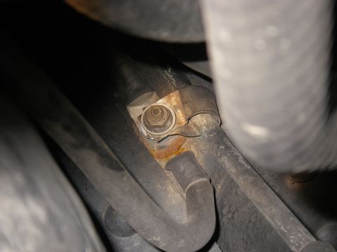 1990 Ford Bronco - Close-up of a rusted bracket and hoses, likely from a vehicle's engine bay.