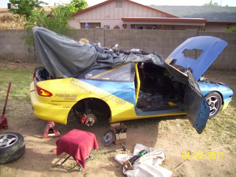1995 Ford Probe - This 1995 Ford Probe is in a state of repair, with its hood and door open, revealing its interior and engine bay.