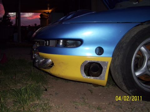 1995 Ford Probe - Customized car front bumper features a two-tone blue and yellow paint scheme with an exposed exhaust pipe and aftermarket modifications.