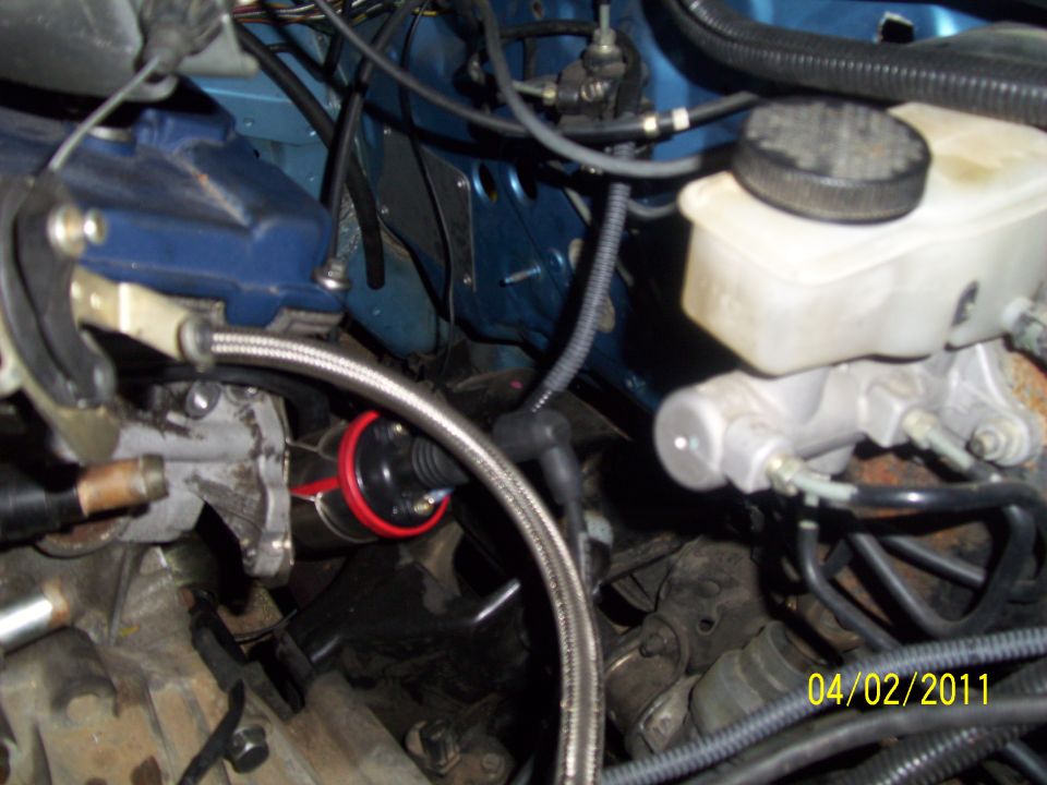 Close-up of engine bay with brake fluid reservoir and ignition coil