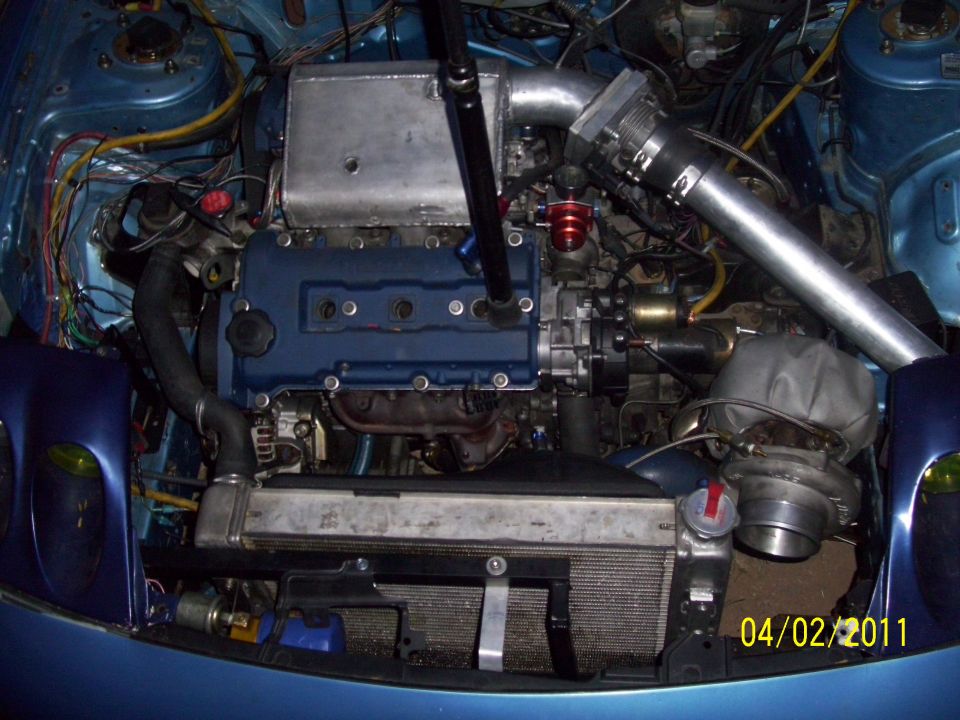 engine bay with blue valve cover, intercooler, and turbocharger