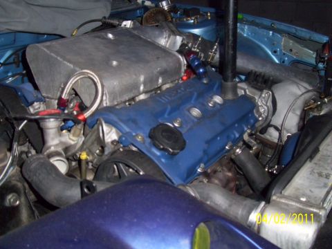 1995 Ford Probe - Close-up view of a modified engine bay, showing custom intake and blue valve cover.