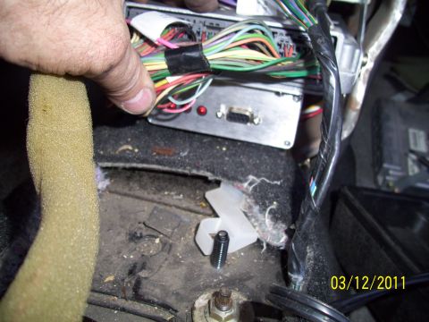 1995 Ford Probe - Wiring harness and computer module in a car's interior, with a hand manipulating the wires.