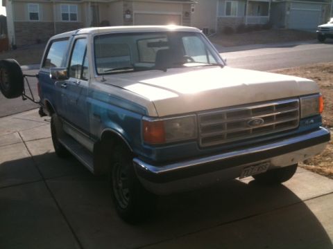 1988 Ford Bronco - This 1988 Ford Bronco features a two-tone blue and white paint scheme and a spare tire carrier on the back.