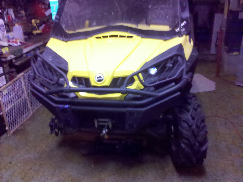 Yellow Can-Am ATV with black front bumper and brush guard