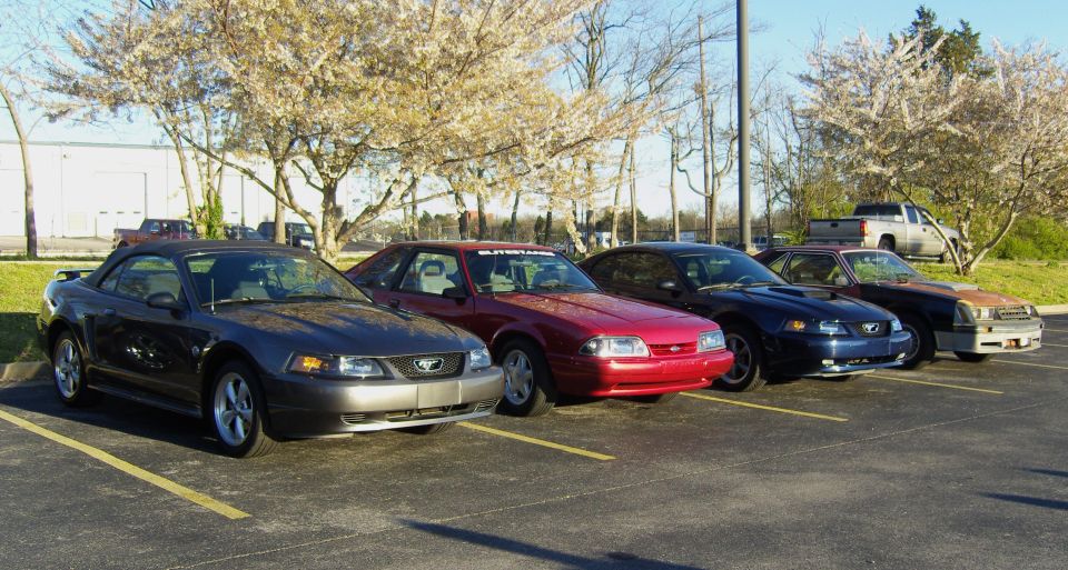 Dark gray convertible Mustang parked in a lot, front 3/4 view