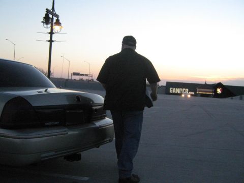2000 Mercury Grand Marquis - A man walks away from a Mercury Grand Marquis in a parking lot as the sun sets.