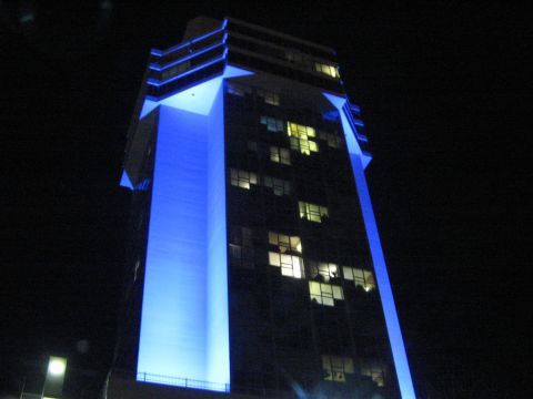 2000 Mercury Grand Marquis - A building is illuminated with bright blue lights against the dark night sky.