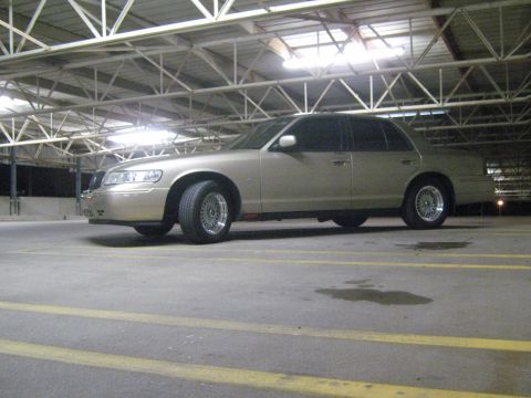 2000 Mercury Grand Marquis - A 2000 Mercury Grand Marquis is parked in a covered lot with yellow lines on the ground.
