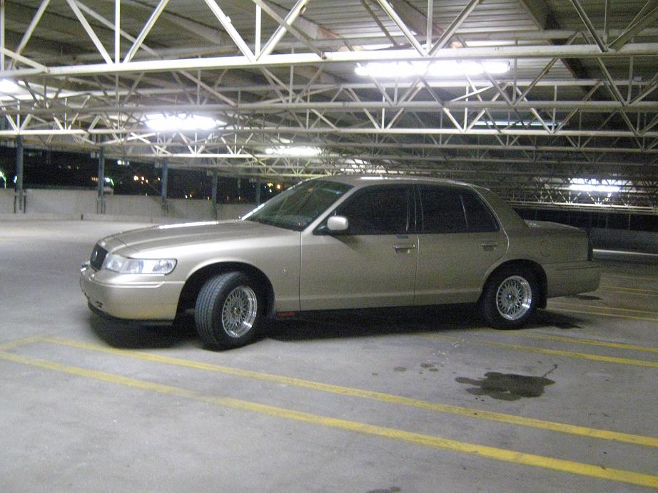 Gold sedan parked in a parking garage. Looks like a 2000 Mercury Grand Marquis