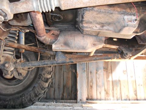 1996 Ford Bronco - Undercarriage view of a 1996 Ford Bronco, revealing the exhaust system and transmission pan with Ford branding.