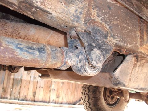 1996 Ford Bronco - Close-up view of the undercarriage, showing the driveshaft and suspension system of a vehicle.