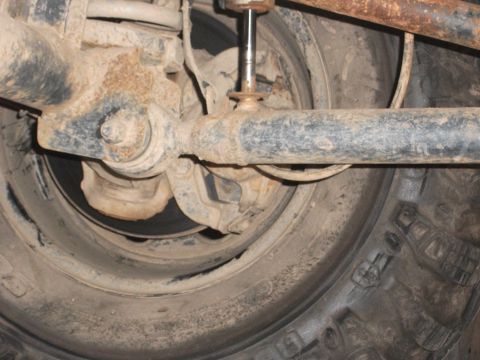1996 Ford Bronco - Undercarriage view of a vehicle's rear suspension and tire assembly.