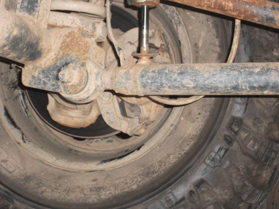 Close-up of a vehicle's rear axle, shock absorber, and tire