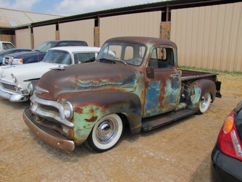 2006 BMW 5 Series - This heavily rusted pickup truck features a classic body style and whitewall tires, parked alongside other vehicles.