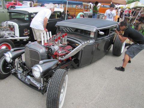 2006 BMW 5 Series - A photographer captures a custom hot rod with a prominent V8 engine at an outdoor car show.