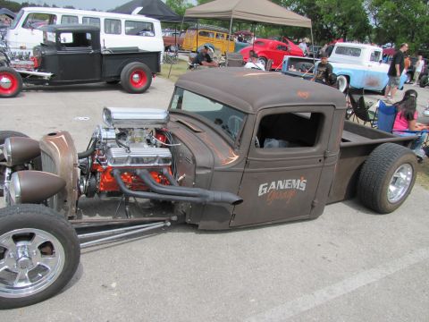 2006 BMW 5 Series - Custom hot rod pickup truck with exposed engine and "GANEMS Garage" lettering on door, seen at an outdoor event.