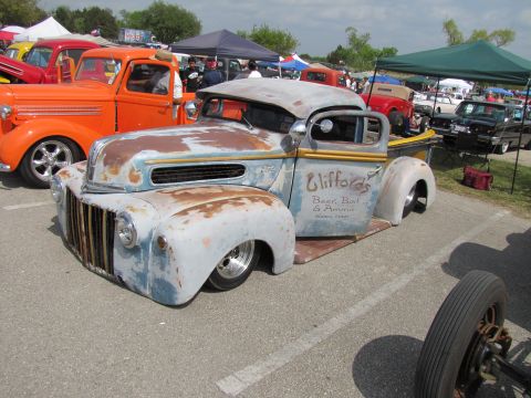 2006 BMW 5 Series - A heavily customized and rusted pickup truck, known as a rat rod, is parked at an outdoor event.