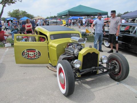 2006 BMW 5 Series - A custom yellow hot rod is displayed at an outdoor event with spectators and other vehicles present.