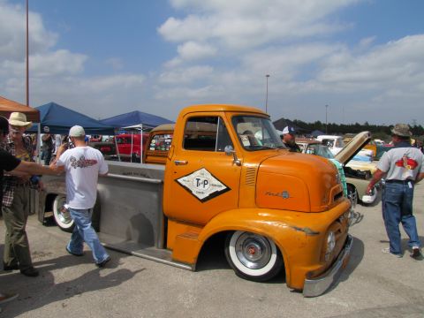 2006 BMW 5 Series - This orange Ford truck features a custom diamond logo on its door and appears to be at a car show.